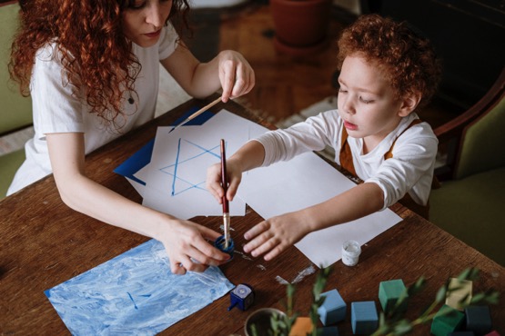 2 kids drawing at table